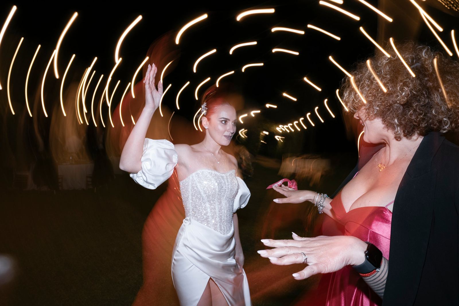 La sposa balla tra le scie delle luci, in un mosso notturno