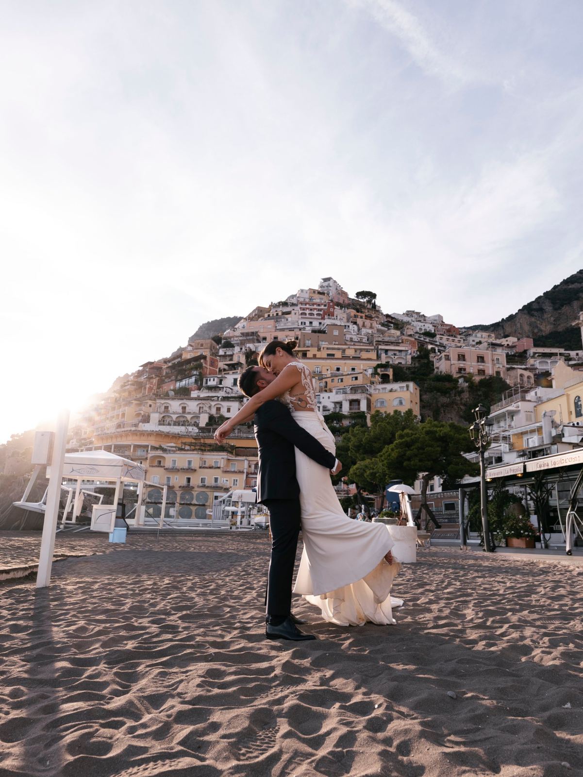 Lo sposo solleva la sposa sulla spiaggia di Positano