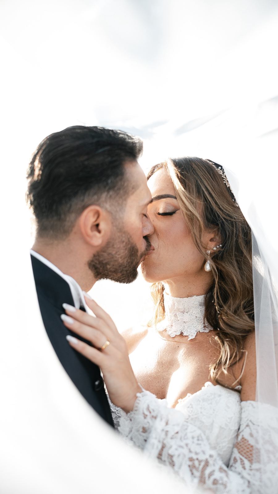 Il bacio degli sposi sotto il velo, in piena luce